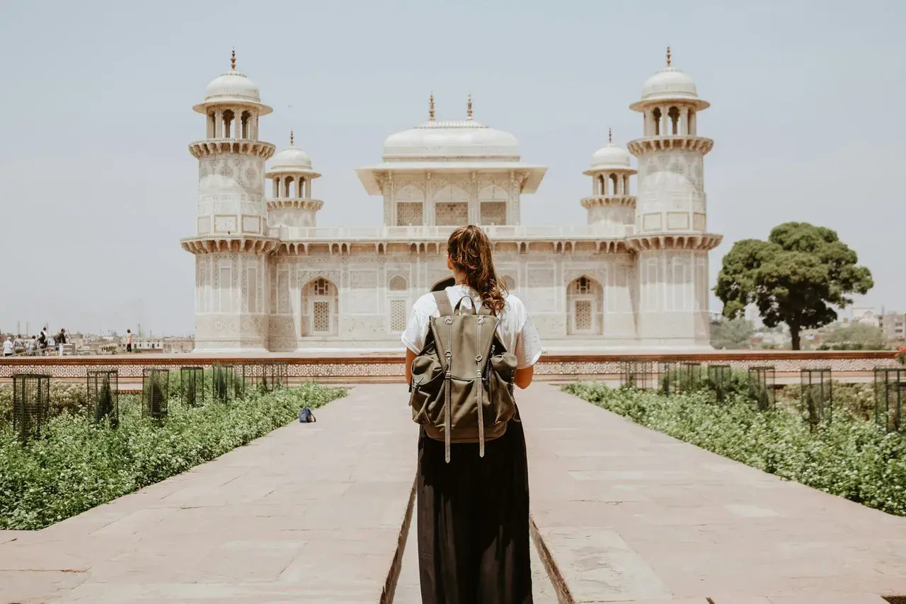 Traveler standing before a palace, the kind of trips Ember Travel Co. books
