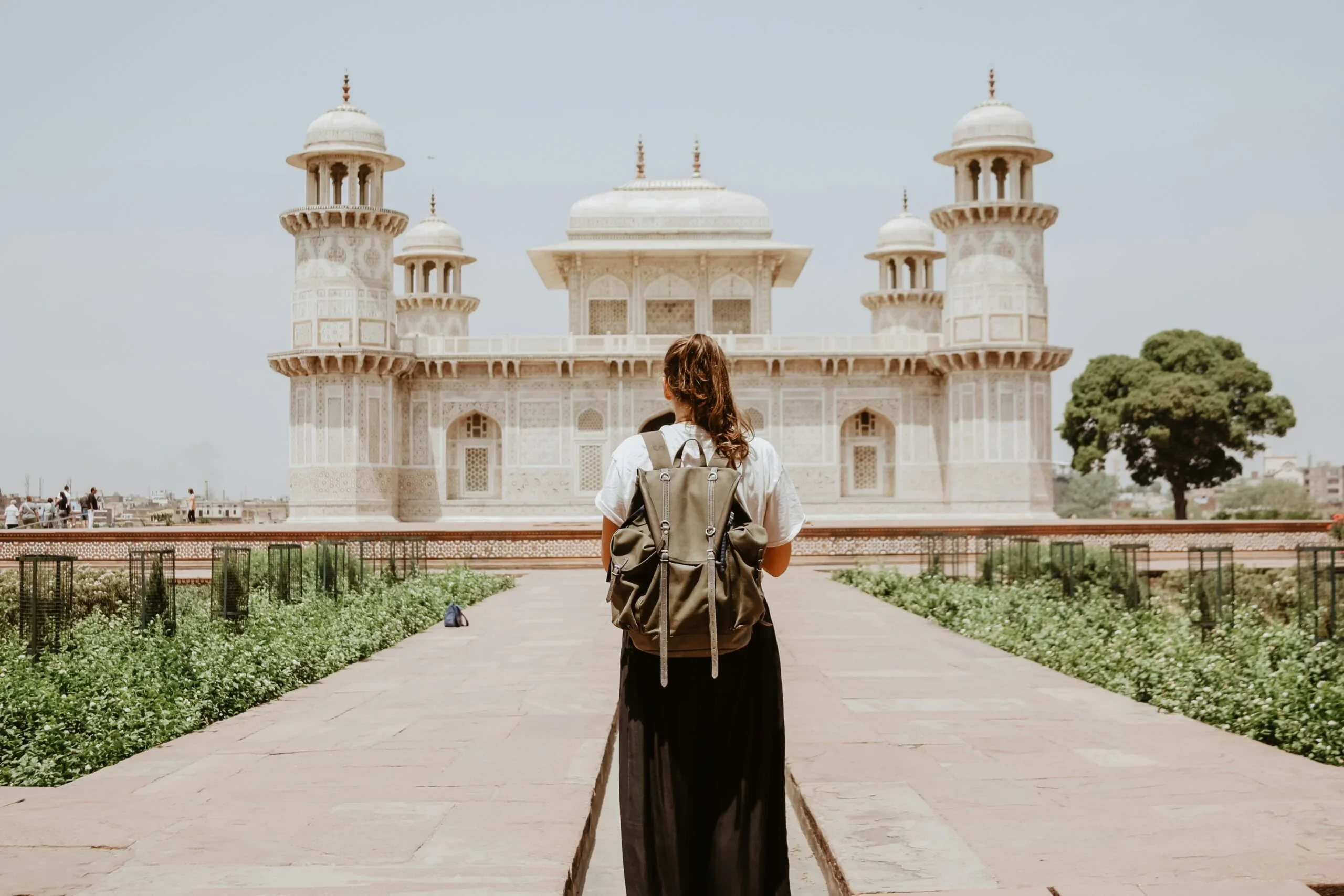 Traveler standing before a palace, the kind of trips Ember Travel Co. books